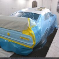 car prepped for paint within paint booth