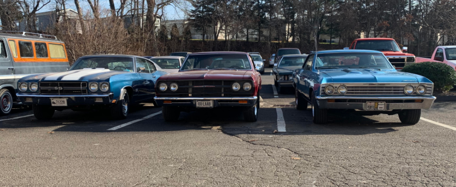 three classic cars in a parking lot